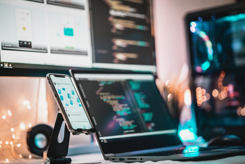 Close-up view of a tech setup with gadgets and coding screen