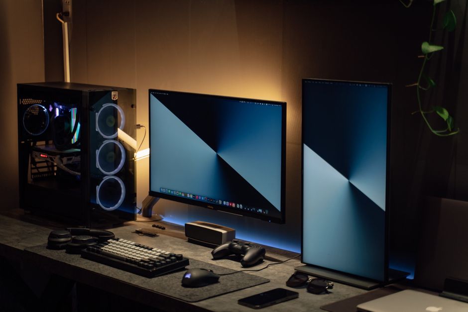 Modern dual monitor PC setup with tech gadgets on a sleek desk