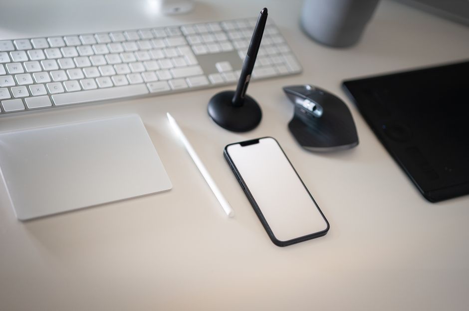 Clean and modern workspace featuring keyboard, smartphone, and wireless mouse